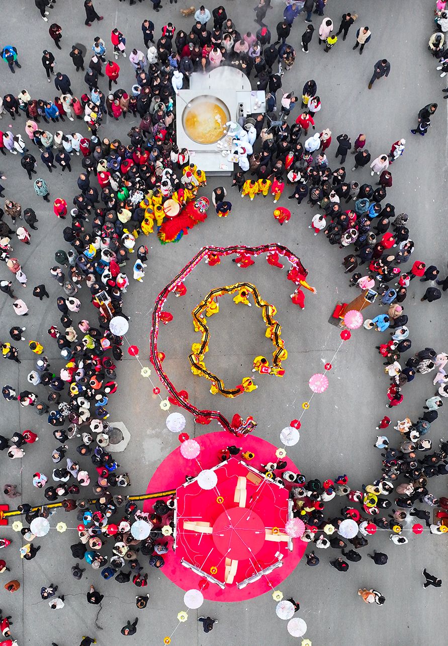 市民一遍品尝鲜美的汪集鸡汤，一遍欣赏精彩的舞龙表演。叶东辉 摄.jpg.jpg